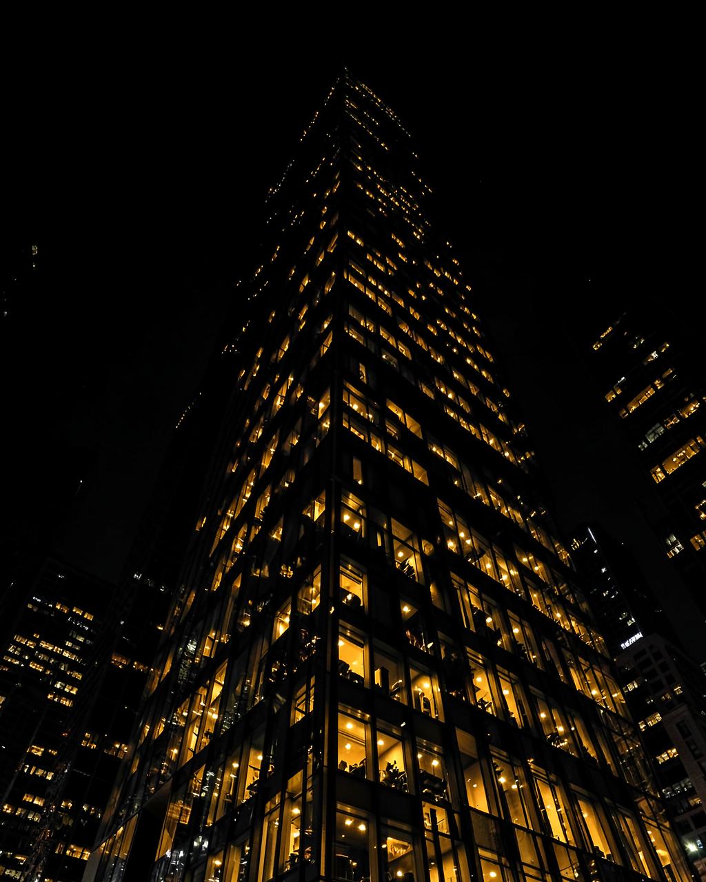 Edifício corporativo iluminado em dourado à noite